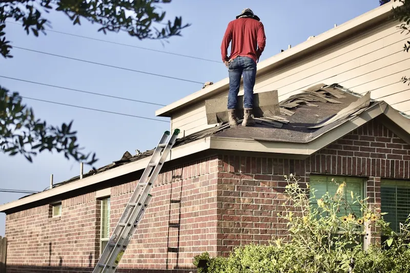 Professional roofer working on a residential roof in Malverne